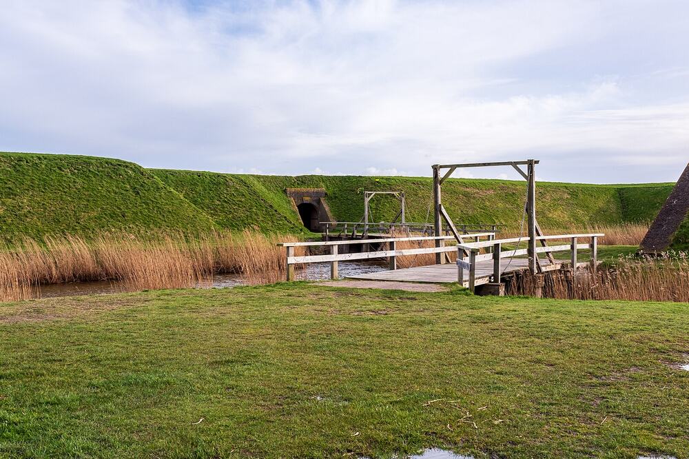 De houten ophaalbrug en groene wallen van Fort de Schans bij Oudeschild op Texel