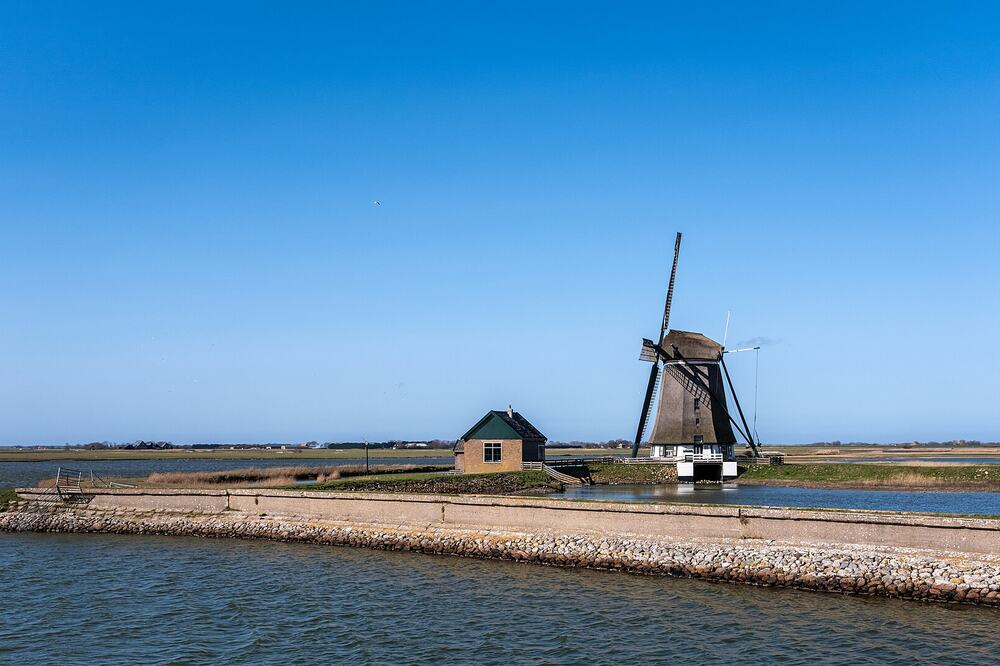 Molen Het Noorden bij Oosterend op Texel, aan het water onder een strakblauwe lucht